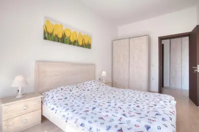 a bedroom with a bed and a painting of yellow tulips at Premium Lea Apartments in Ulcinj