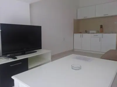 a living room with a television and a white table at Luxury Villas Marko in Tivat