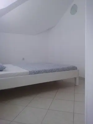 a bed in a room with a white wall at Luxury Villas Marko in Tivat