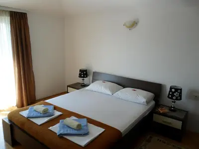 a hotel room with a bed with towels on it at Apartments Kalluka in Sveti Stefan