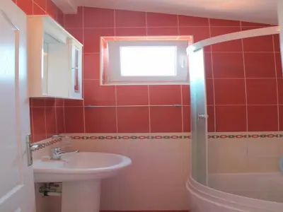 a red bathroom with a sink and a window at Apartments Galija in Petrovac na Moru