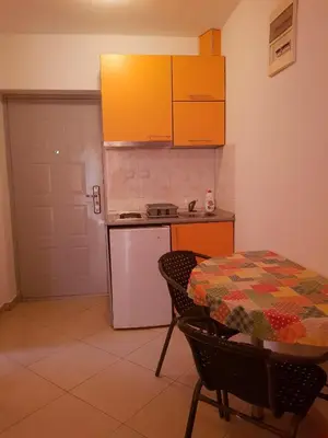 a kitchen with a table and a stove and a refrigerator at Apartments Galija in Petrovac na Moru