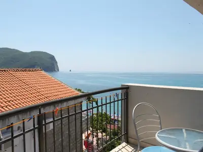 a balcony with a table and chairs and the ocean at Apartments Galija in Petrovac na Moru