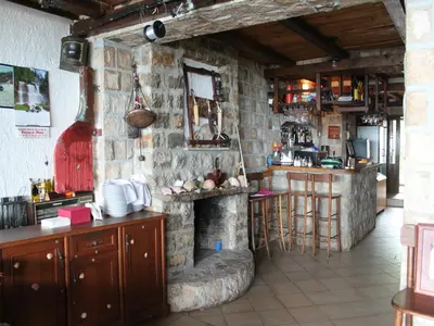 a kitchen with a stone fireplace in a room at Apartments Galija in Petrovac na Moru