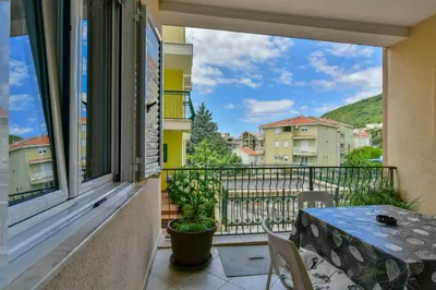 a balcony with a table and a view of a city at Apartments Srzentic in Petrovac na Moru