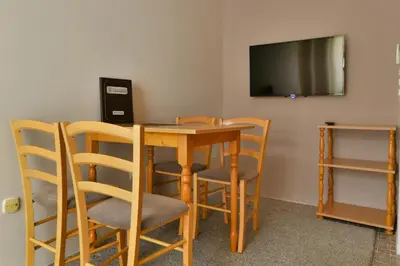 a room with a table and chairs and a television at Apartments Srzentic in Petrovac na Moru