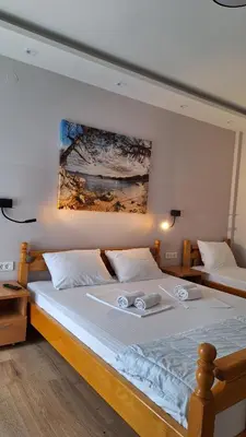 a bedroom with two beds and a painting on the wall at Apartments Srzentic in Petrovac na Moru