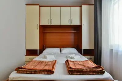 a bed with two pillows on top of it at Apartments Srzentic in Petrovac na Moru