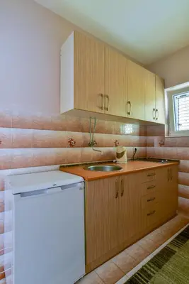 a kitchen with wooden cabinets and a sink at Apartments Srzentic in Petrovac na Moru