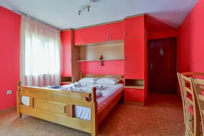 a red bedroom with a bed and red cabinets at Apartments Srzentic in Petrovac na Moru