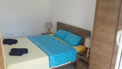 a bedroom with a bed with two blue pillows at Apartments Stevo Nikočević in Bar