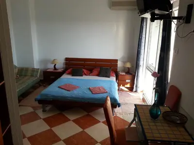 a bedroom with a bed with a blue comforter at Apartments Stevo Nikočević in Bar