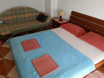 a bedroom with a large bed and a couch at Apartments Stevo Nikočević in Bar