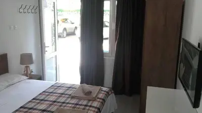 a bedroom with a bed and a window with a car outside at Apartments Stevo Nikočević in Bar