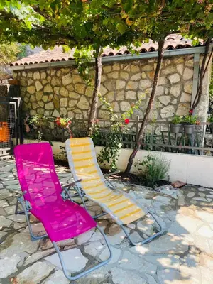 two lawn chairs sitting next to a stone wall at Lake View Apartment Dodosi in Dodoši