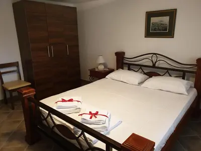 a bedroom with a bed with white sheets and red bows at Lake View Apartment Dodosi in Dodoši