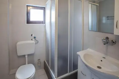 a bathroom with a toilet and a shower and a sink at Mali Miločer Bay Accommodation in Sveti Stefan