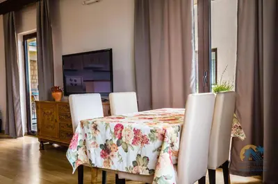 a dining room with a table with a floral table cloth at Mali Miločer Bay Accommodation in Sveti Stefan