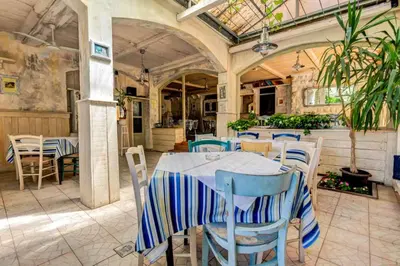 a dining room with a table and chairs at Mali Miločer Bay Accommodation in Sveti Stefan