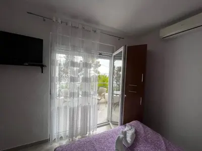 a bedroom with a bed and a sliding glass door at Apartmani Sunce in Bar