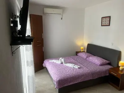 a bedroom with a purple bed with two white towels at Apartmani Sunce in Bar
