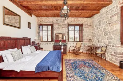 a bedroom with a bed and a stone wall at Kotor Nest in Kotor