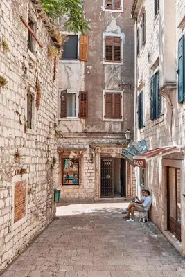 two people sitting in a chair in front of a building at Kotor Nest in Kotor