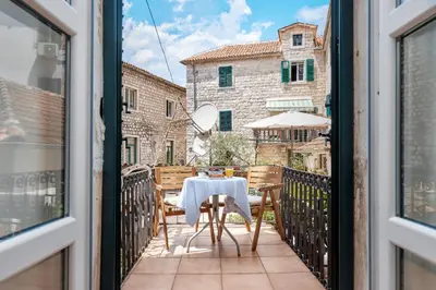 a table and chairs on the balcony of a building at Kotor Nest in Kotor