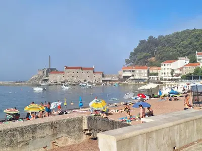 a group of people on a beach with umbrellas at Milena in Petrovac na Moru