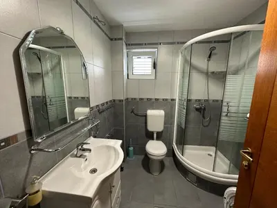 a bathroom with a sink and a shower and a toilet at Apartments Villa Pržno in Sveti Stefan