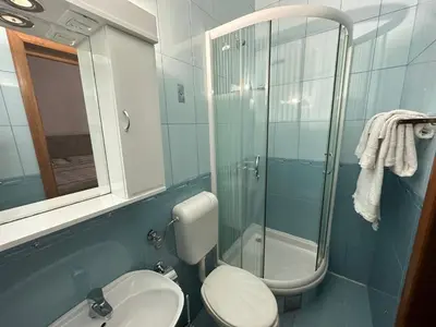 a bathroom with a toilet and a glass shower at Apartments Villa Pržno in Sveti Stefan