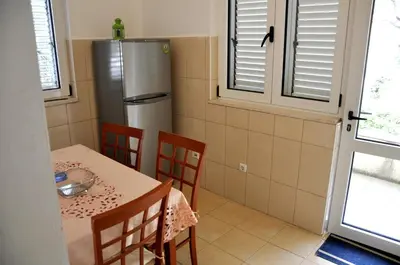 a kitchen with a table and a refrigerator at Apartments Villa Pržno in Sveti Stefan