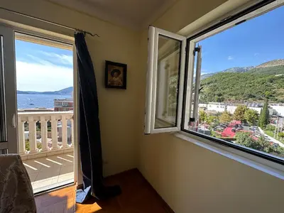 a room with two windows and a view of the ocean at Apartments Villa Pržno in Sveti Stefan