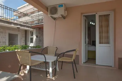 a patio with a table and chairs and a balcony at Apartments Grand in Sveti Stefan