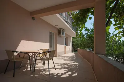 a patio with a table and chairs on the side of a building at Apartments Grand in Sveti Stefan
