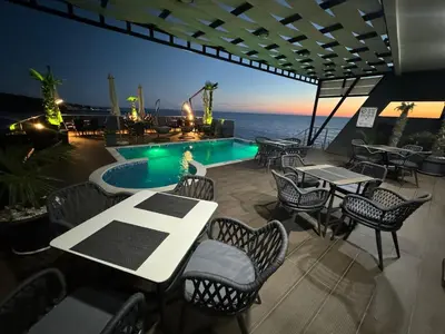 a patio with tables and chairs and a swimming pool at Apart Lux Beciragic in Dobra Voda