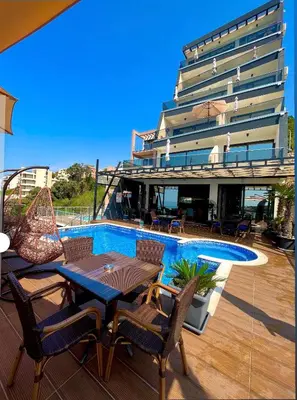 a patio with a table and chairs and a building at Apart Lux Beciragic in Dobra Voda