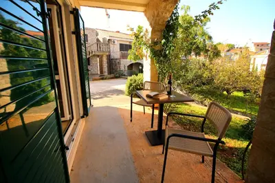 a patio with a table and chairs on a porch at Guest House Villa Pastrovka in Sveti Stefan