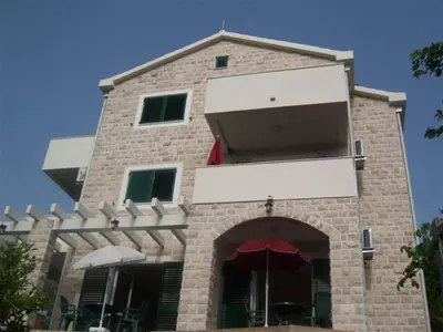 a tall brick building with an archway in front of it at Guest House Villa Pastrovka in Sveti Stefan