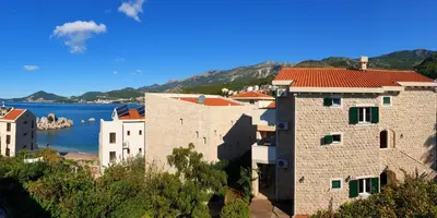 a group of buildings next to a body of water at Guest House Villa Pastrovka in Sveti Stefan