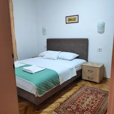 a bed with two pillows on it in a bedroom at Apartmani Asanović in Budva