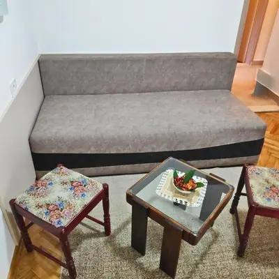 a bed with two chairs and a table in a room at Apartmani Asanović in Budva