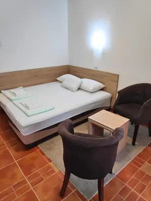 a bed and a chair in a room at Apartmani Asanović in Budva
