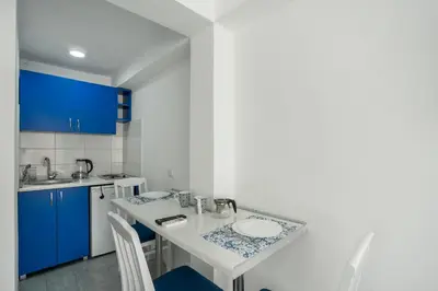 a kitchen with blue cabinets and a table and chairs at Apartments Natali in Bar