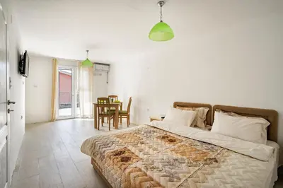 a bedroom with a bed and a table and chairs at Apartments Natali in Bar