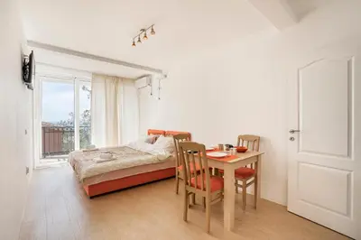 a bedroom with a table and a bed and a window at Apartments Natali in Bar