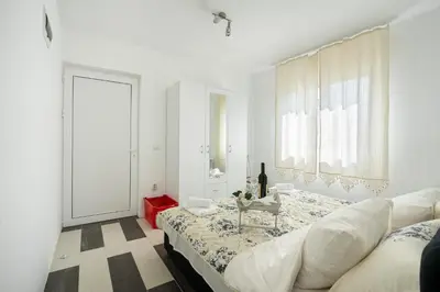 a white room with a bed and a table at Apartments Natali in Bar