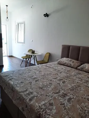 a bedroom with a bed and a table with chairs at Apartments Kingfisher in Virpazar