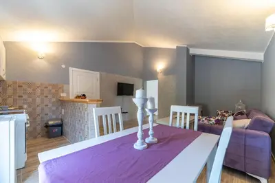 a living room with a table with a purple table cloth at Apartments Kingfisher in Virpazar