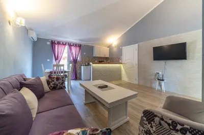 a living room with a couch and a table at Apartments Kingfisher in Virpazar